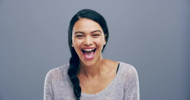 Face, humor or happy woman in studio laughing at joke or crazy comedy isolated on gray background. Funny lady, model or female person with freedom, silly smile or joy to relax alone with energy. - Footage, Video