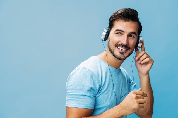 Веселий чоловік насолоджується фоновим співом студія розмовляє копією хлопця космічна футболка портрет емоції радість вирізати музичні навушники на синьому онлайн-житті щасливий - Фото, зображення