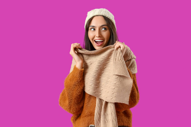 Jonge vrouw in de winter kleding op paarse achtergrond - Foto, afbeelding