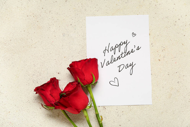 Card with text HAPPY VALENTINE'S DAY and red roses on light grunge background - Photo, image