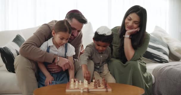 Eltern, Kinder und Schach spielen zu Hause in der jüdischen Familie, lernen Strategie oder Wettbewerb. Mutter, Vater oder Geschwister unterstützen oder unterstützen gemeinsam religiöses Ereignis, Kompetenzentwicklung oder Elternverbindung. - Filmmaterial, Video