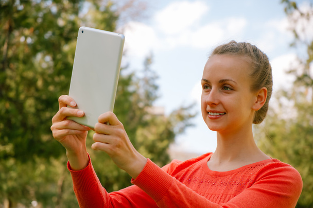 Jeune femme faisant selfie avec tablette dans le parc vert
 - Photo, image