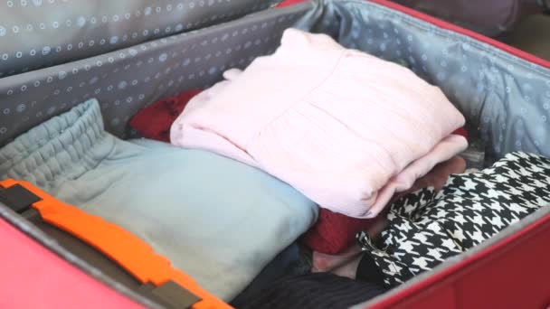  A nők kihozzák az összes ruhát a bőröndből. . - Felvétel, videó