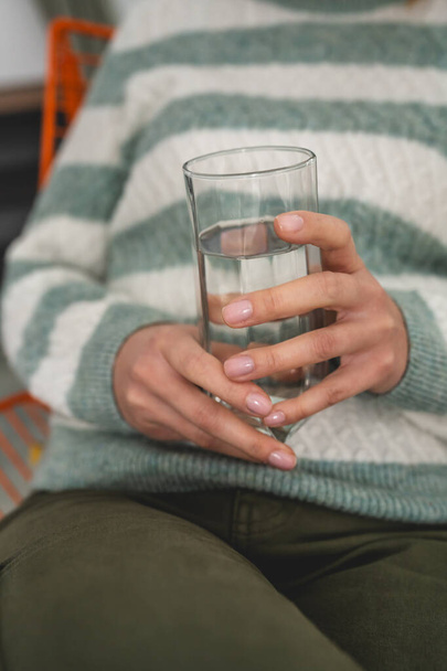zblízka na střední části neznámé bělošky drží sklenici vody - Fotografie, Obrázek