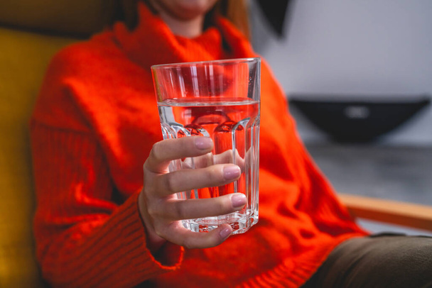 close up on midsection of unknown caucasian woman hold glass of water - Photo, Image
