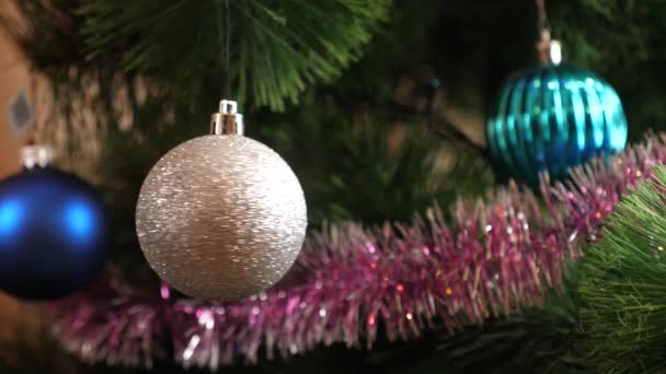 L'ornamento lucido dell'albero di Natale ruota mentre è appeso all'albero di Natale. Rallentatore. - Filmati, video