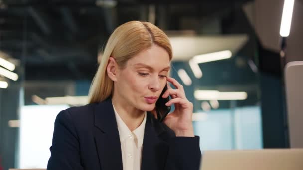 オフィスの職場でスマートフォンで話すビジネス女性. 忙しい起業家は,屋内で携帯電話を呼び出すメモを作っています. ノートブックに気づくクライアントの質問に答えるかわいい女性マネージャー - 映像、動画