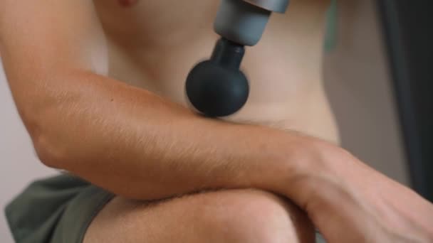 A guy massages his brachioradialis muscle with a percussion massager, close-up. High quality 4k footage - Footage, Video