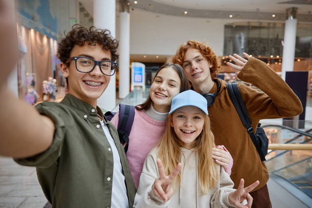 Heureux amis adolescents prenant selfie par caméra téléphonique au centre commercial. Meilleures vibrations et moments amusants pendant le centre de magasin de visite récréative - Photo, image