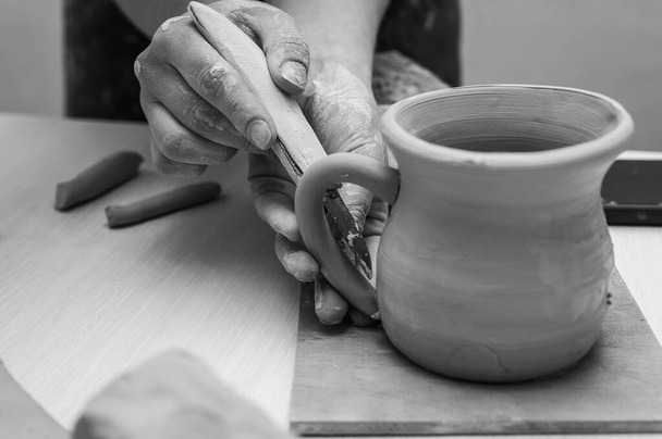 Чорно-біле фото, глина, кераміка або руки в дизайнерській майстерні, що працює на художній чашці або кухоль в маленькій бізнес-студії. Робить ремесла в скульптурі - Фото, зображення