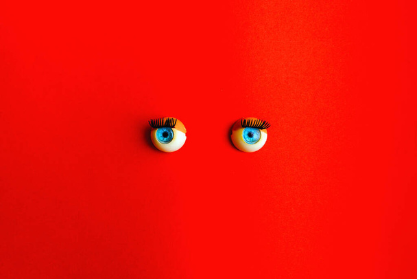 toy eyes dolls, red surface,copy space. - Photo, Image