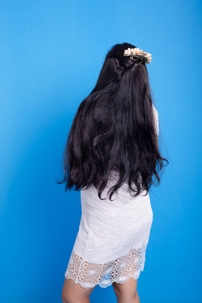 Красива молода жінка в білій сукні з оболонкою тіара на голові, показуючи її чорне волосся. Характеризується Іманьєю. - Фото, зображення