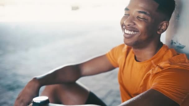 Zwarte man, glimlach en gezicht, ontspannen na het sporten met geluk, welzijn en gezondheid buiten. Atleet neemt pauze van training, sport en fitness portret, loper rust na training met tevredenheid. - Video