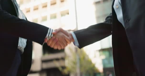 Business people, handshake and city for partnership, agreement or greeting in outdoor deal or meeting. Closeup of employees shaking hands outside for b2b, teamwork or hiring in an urban town together. - Footage, Video