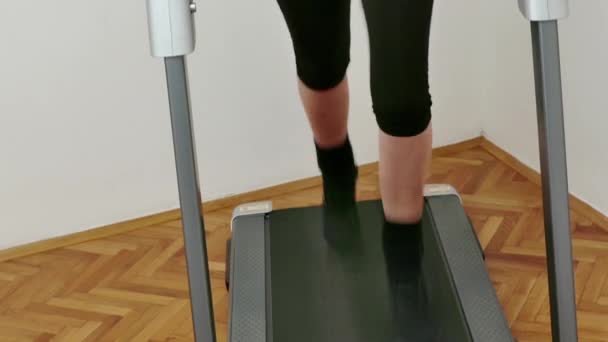 Fiatal nő gyakorolja, és tartja fitt egy futópad otthon, Video Clip 4K - Felvétel, videó