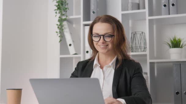 A businesswoman in a stylish office: successful, dynamic and always at the forefront of events. A successful female leader rejoices in an achievement. Female student and student of business university - Záběry, video