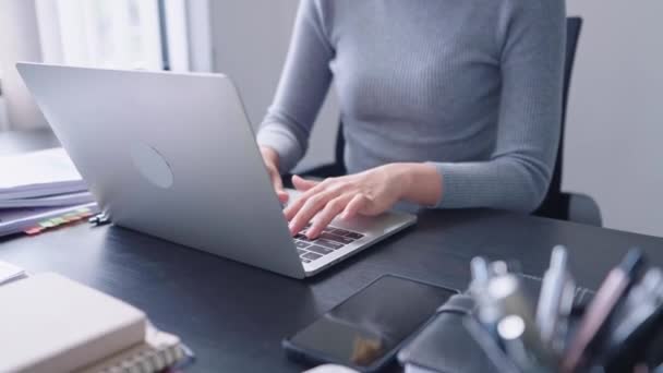 Pewna siebie azjatycka bizneswoman pracuje na laptopie, używając analitycznego myślenia, by pilnie skupić się na swoich zadaniach. Wykazuje silną etykę pracy i determinację.. - Materiał filmowy, wideo