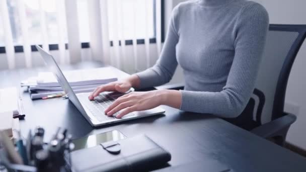 Впевнена азіатська бізнес-леді працює на своєму комп'ютерному ноутбуці, використовуючи аналітичне мислення, щоб зосередитися на своїх завданнях старанно. Вона демонструє сильну робочу етику та рішучість. - Кадри, відео