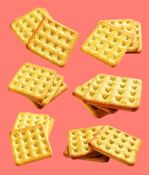 Square crackers isolated or biscuits, butter cookies with clipping path, no shadow in pink background - Фото, изображение