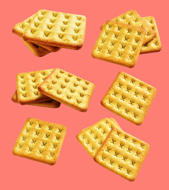 Square crackers isolated or biscuits, butter cookies with clipping path, no shadow in pink background - Foto, Imagen