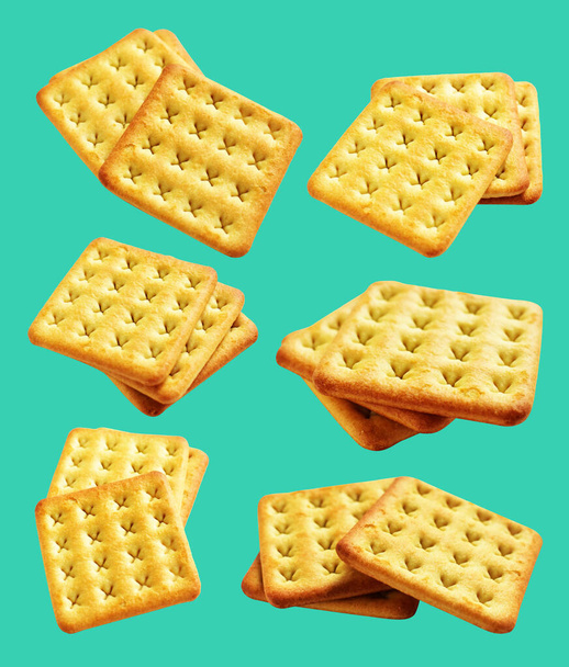 cracker quadrati isolati o biscotti, biscotti al burro con percorso di ritaglio, nessuna ombra sullo sfondo verde - Foto, immagini