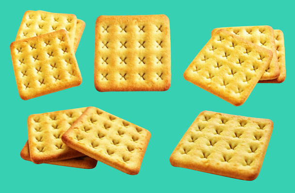 Квадратные крекеры изолированы или печенье, масло печенье с обрезкой пути, без тени на зеленом фоне - Фото, изображение