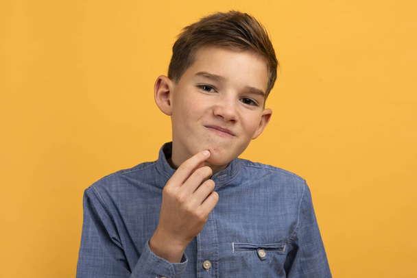 Teen Skin Problem. Upset Teenage Boy Touching Pimple On His Face And Looking At Camera, Frustrated Young Male Kid Suffering Acne On Chin, Standing On Yellow Studio Background, Closeup Shot - Fotografie, Obrázek