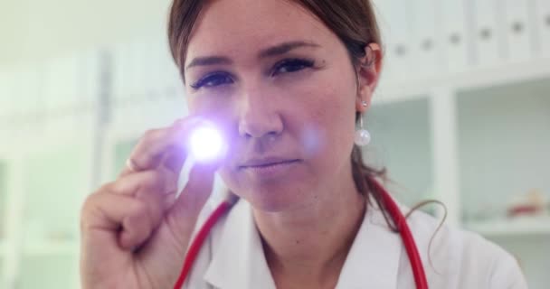 Doctor shining flashlight into eyes of patient with coma to determine reflexes 4k movie slow motion. Diagnosis and treatment of emergency conditions in medicine concept - Imágenes, Vídeo