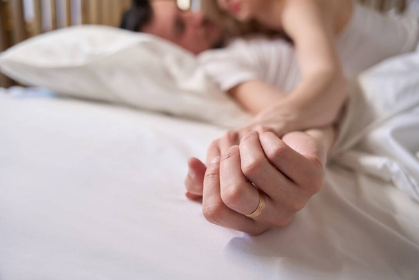 Beautiful woman hugging her husband in bed, couple staying in honeymoon suite - Foto, Bild