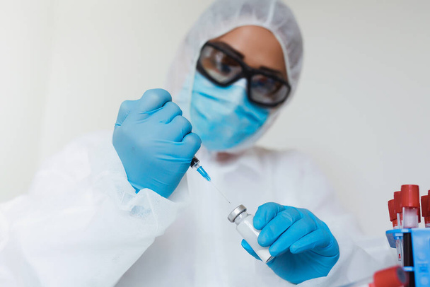 Vacuna COVID. Trabajador médico competente pasa su tiempo de trabajo en el laboratorio mientras investiga la enfermedad por coronavirus. - Foto, imagen