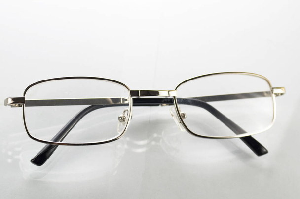 Óculos com armações metálicas sobre um fundo branco - Foto, Imagem