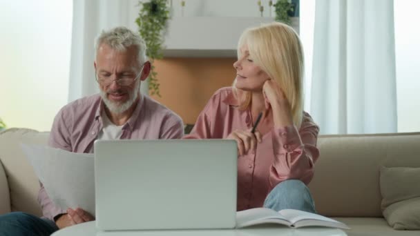 Tyytyväinen perhe pari Valkoihoinen mies nainen isovanhemmat asiakkaat puhuvat tarkistaa papereita käyttämällä kannettavaa tietokonetta suunnittelu budjetti sijoitus laina vakuutus maksu kotona maksettu velka onnistunut sopimus - Materiaali, video