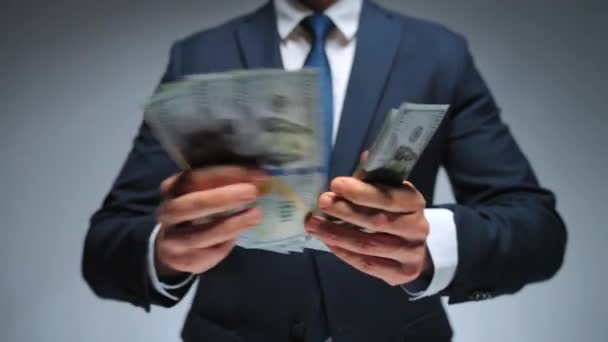 Muodollisesti pukeutunut mies laskee Yhdysvaltain dollarin seteleitä, lähikuva. Investoinnin, menestyksen, taloudellisten näkymien tai uralla etenemisen käsite. - Materiaali, video