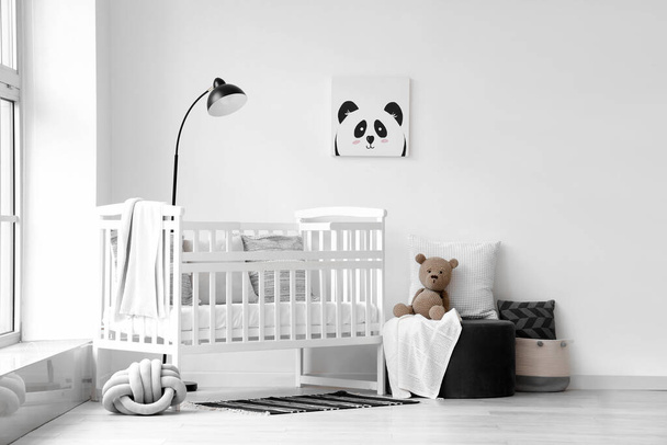 Stijlvol interieur van kinderkamer met babybed en poef - Foto, afbeelding