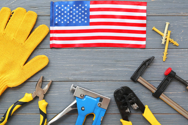 Composition with different tools, gloves and USA flag on grey wooden background. Labor Day celebration - Foto, Imagen