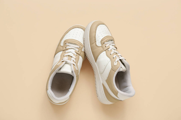 Zapatillas de deporte con estilo sobre fondo beige - Foto, Imagen