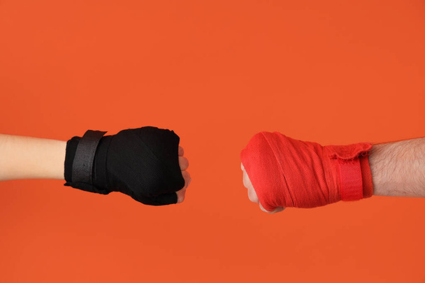 Female hands in boxing bandages on orange background - Foto, Bild