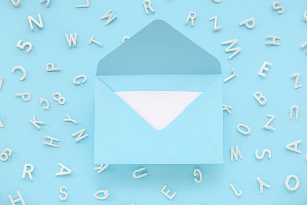 Open envelope with scattered letters on blue background - Foto, Imagem
