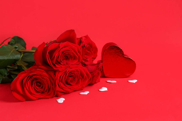 Roses with gift box in shape of heart on red background - Fotó, kép