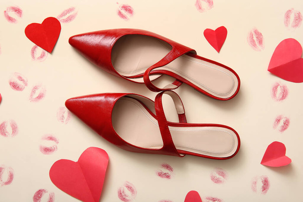 Stylish female shoes, paper hearts and lipstick kiss marks on color background. Valentine's Day celebration - Zdjęcie, obraz