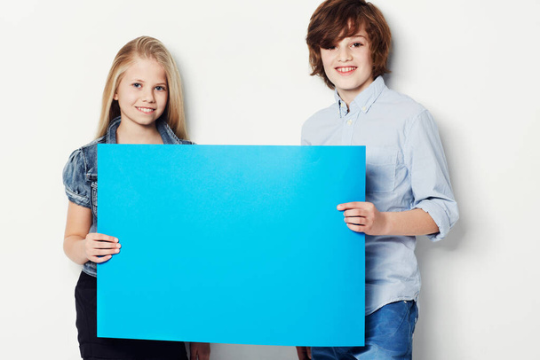 Happy teens, portrait and billboard for advertising, marketing or mockup space on a white studio background. Young man and woman or gen z smile with blue poster or empty sign for presentation or vote. - Photo, Image