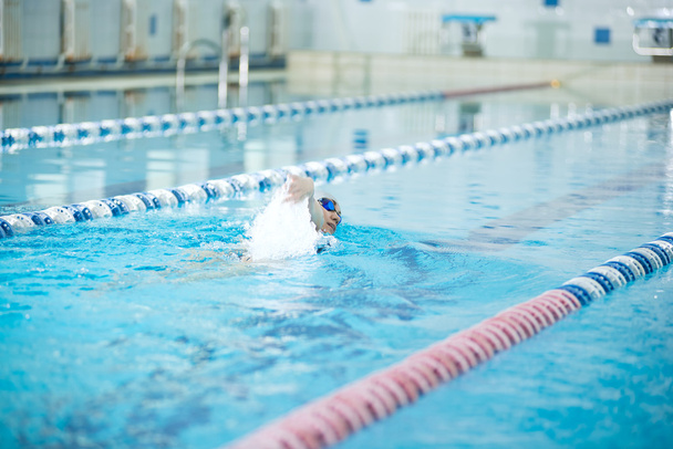 Young girl in goggles swimming front crawl stroke style - Photo, Image