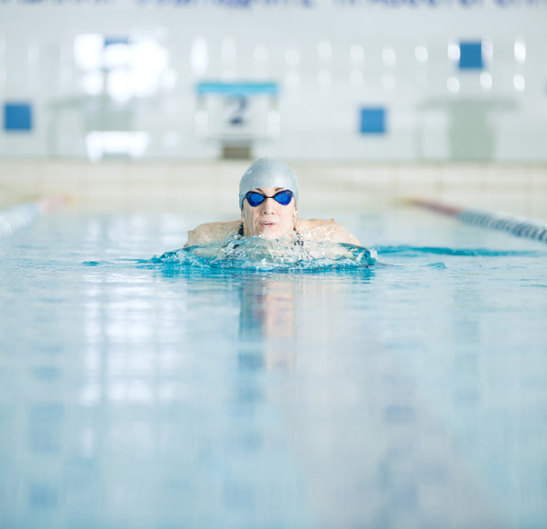 junges Mädchen mit Brille schwimmt Brustschwimmen - Foto, Bild