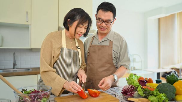 gelukkig aziatisch gepensioneerd paar voorbereiding gezond vegetarisch lunch en tijd doorbrengen samen - Foto, afbeelding