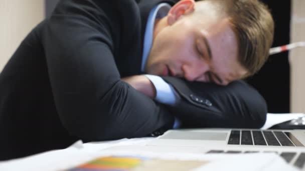 Dolly shot to tired boss in formal suit falling asleep on table at boardroom. Exhausted manager sleeping on table with laptops at office. Young entrepreneur napping at workplace. Close up Slow motion. - Footage, Video