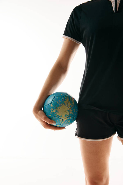 Cropped image of female athlete, professional handball player holding ball against white studio background. Concept of professional sport, movement, dynamic, workout, championship. Ad - Foto, Imagem