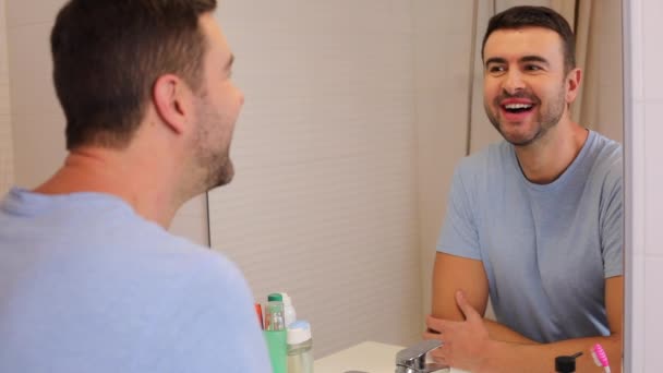 close-up beelden van knappe jonge man in de voorkant van spiegel in de badkamer - Video