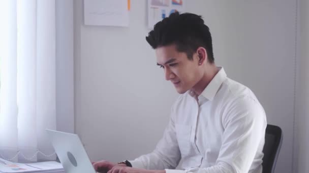 Asian Businessman using laptop computer Does Data Analysis Works on e-Commerce Startup in office. High quality 4k footage - Séquence, vidéo