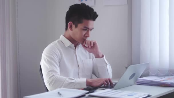 Asian Businessman using laptop computer Does Data Analysis Works on e-Commerce Startup in office. High quality 4k footage - Video, Çekim