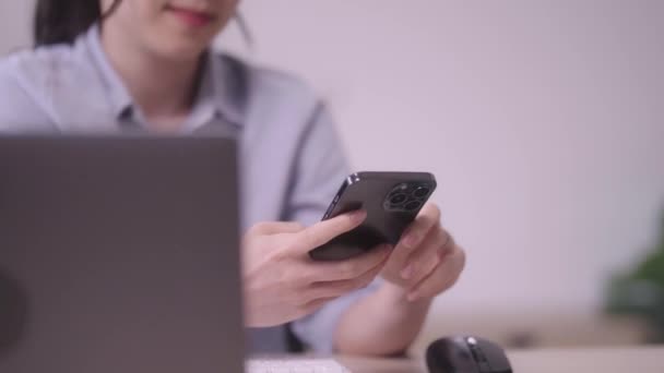 Όμορφη Ασιάτισσα επιχειρηματίας επιχειρηματίας γυναίκα χρησιμοποιώντας μήνυμα κειμένου κινητό τηλέφωνο ή smartphone χρησιμοποιώντας κινητό τηλέφωνο τεχνολογία που εργάζονται στο σαλόνι στο σπίτι. Υψηλής ποιότητας 4k πλάνα - Πλάνα, βίντεο